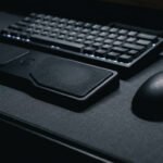DeltaHub Carpio 2.0 BadSeed Tech Edition ergonomic wrist rest on a dark minimalist desk setup next to a wireless gaming mouse.