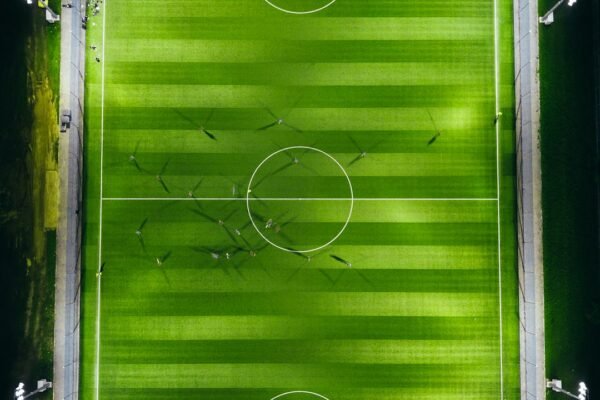 Aerial view of a floodlit soccer stadium and pitch at night