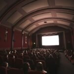 Audience in a dark movie theater watching a bright screen