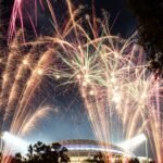 Fireworks exploding over a stadium at night
