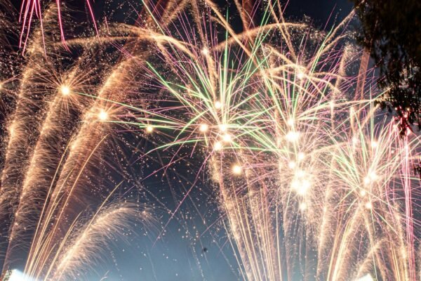 Fireworks exploding over a stadium at night