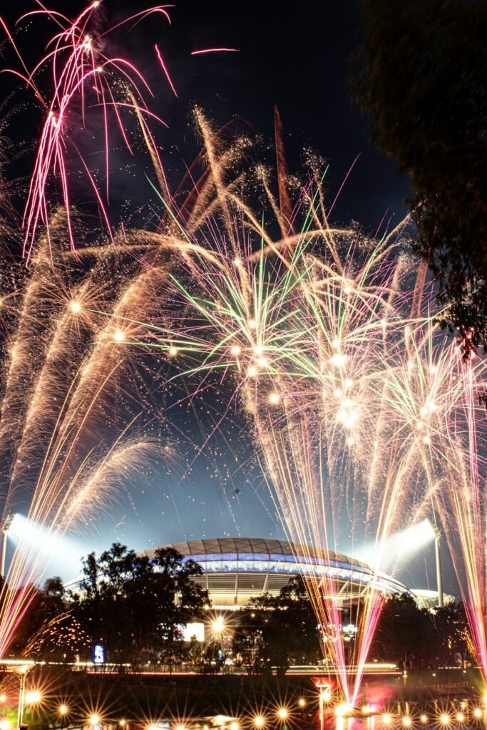 Fireworks exploding over a stadium at night