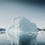 Large iceberg reflected in calm Arctic water near Greenland