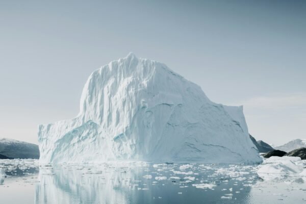 Large iceberg reflected in calm Arctic water near Greenland