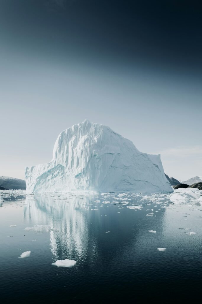 Large iceberg reflected in calm Arctic water near Greenland