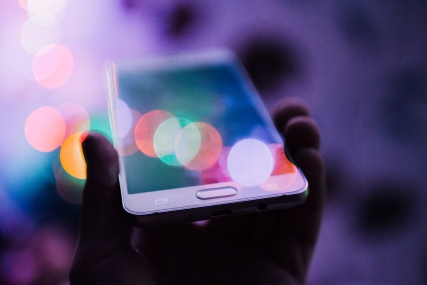 Person holding a smartphone displaying its home screen, illustrating Apple's iPhone 18 Pro launch